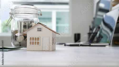 Tableau sur toile Home model and glass jars with coins putting on white table
