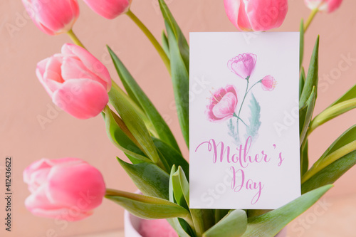 Fototapeta Naklejka Na Ścianę i Meble -  Beautiful flowers and greeting card for Mother's Day on color background