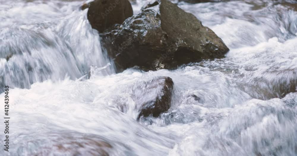 Details with the clear water of a running mountain stream during a cold and sunny winter day in the Romanian Carpathian Mountains. Details with the clear water of a running mountain stream during a cold and sunny winter day in the Romanian Carpathian Mountains.