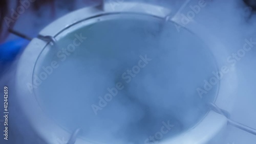Cryogenic container with reproductive cells, Haze and fog comes out from the freezing container. Liquid nitrogen freezer vaccine storage. medical cryogenics biotechnology.