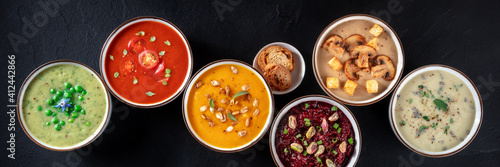 Vegan soup panoramic banner. Various vegetable soups, shot from above, a flat lay on a black background photo