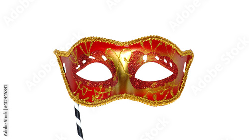 Red mask party or carnival Venetian mask with handle isolated on white background