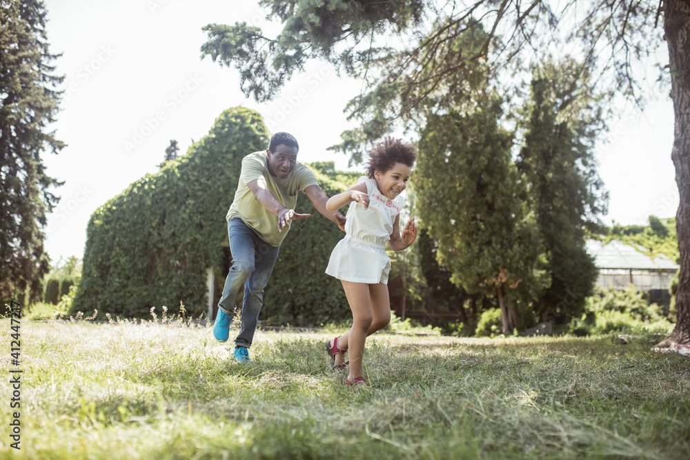 Obraz premium Dad and a cute girl running in the park and feeling happy