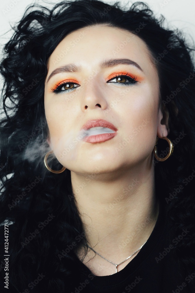 Beautiful young brunette model with bright make-up and curly hairstyle