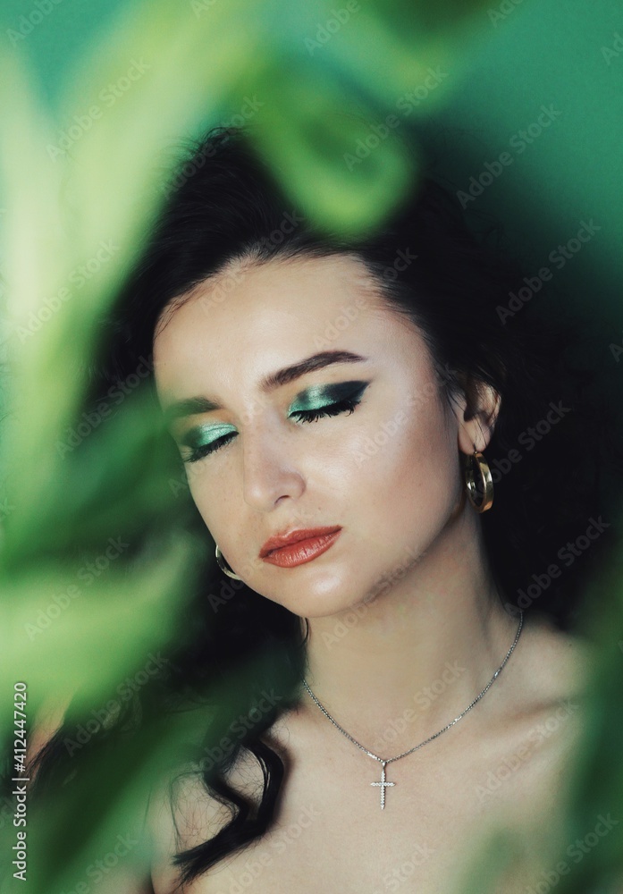 Beautiful young brunette model with bright make-up and curly hairstyle