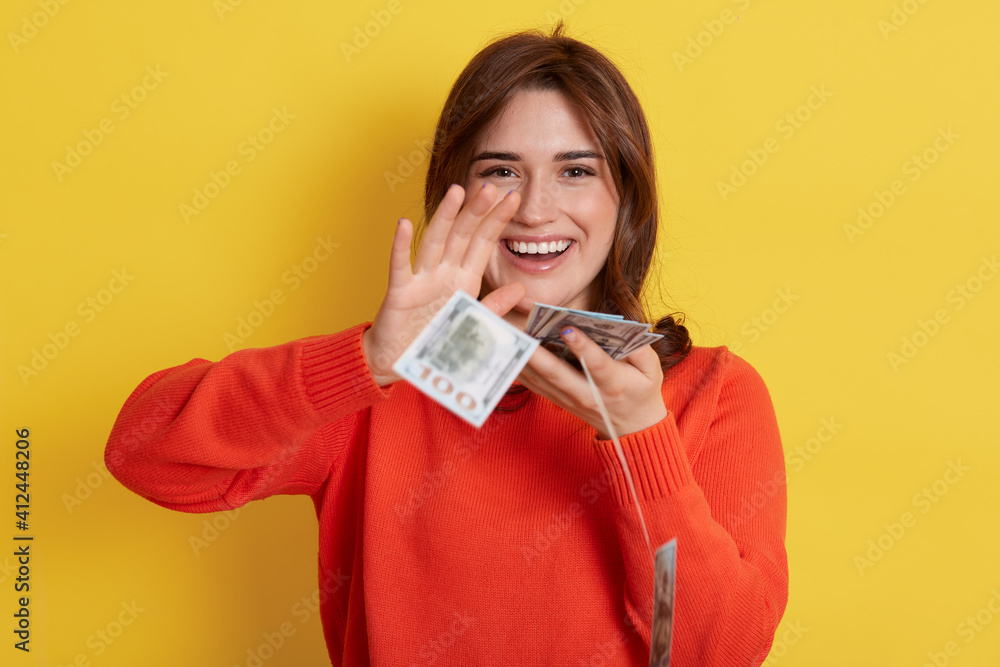 Woman throws up cash, lottery winner with very happy expression, looking directly at camera and smiling, lady with banknotes indoor, dark haired girl with her currency, has reward. Woman throws up cash, lottery winner with very happy expression, looking directly at camera and smiling, lady with banknotes indoor, dark haired girl with her currency, has reward.