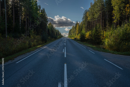 Road traveling the boreal forest showing upward slope with hills in the back © Martijn Krom