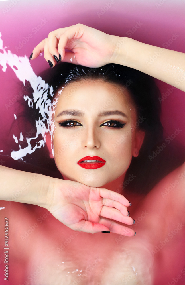 Beautiful young brunette model with bright make-up in bath, water