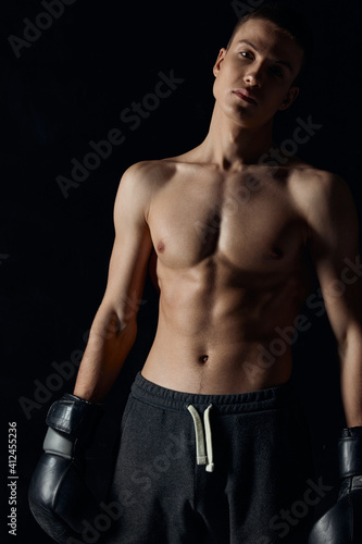 bodybuilders boxing gloves on black background and gray pants athlete model