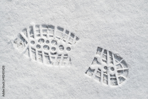 Clearly defined footprint / imprint in fresh snow of rubber lug sole with deep indentations from mountaineering boot / hiking boot in winter