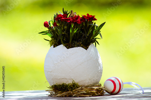 Obraz na płótnie Easter egg as a flower vase in front of a blurred background and a decorative egg w salonie
