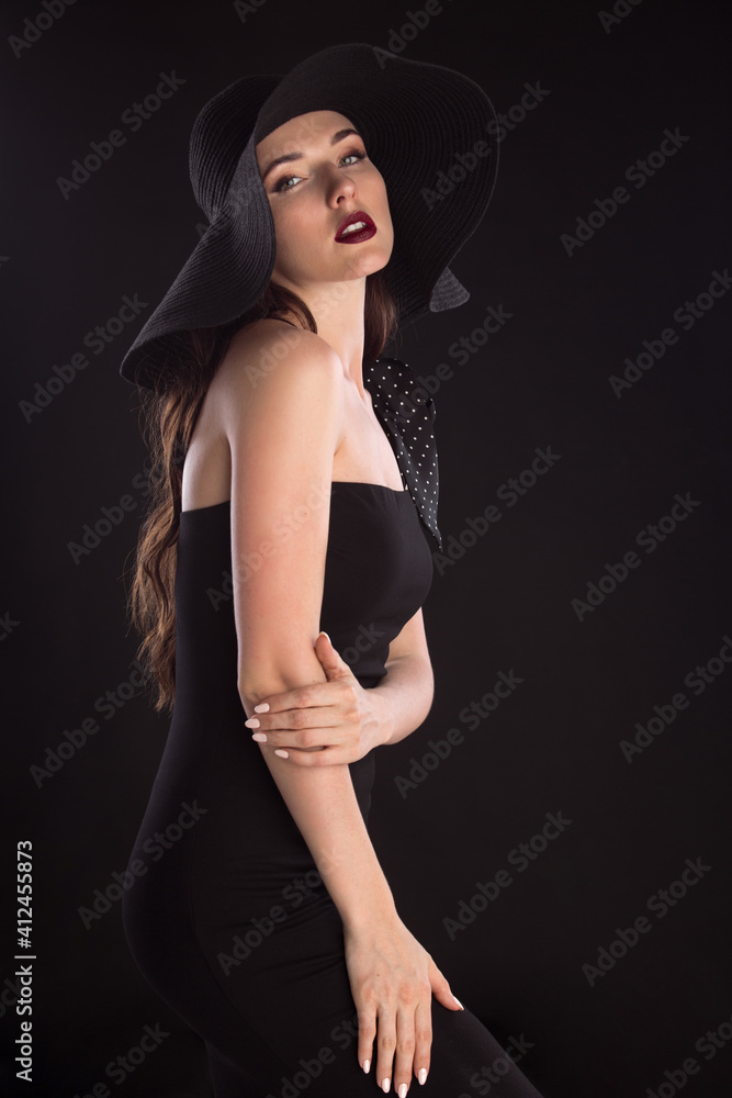 fashion portrait of a young and very beautiful girl in a black hat on a black background fashion portrait of a young and very beautiful girl in a black hat on a black background