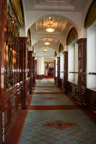 Elegante und luxuriöse Lounge Bar Aufenthaltsraum im Jugendstil auf Luxus Kreuzfahrtschiff mit Sesseln, Vorhängen,, Wurzelholz Wandvertäfelung, Messing, Fenstern und Stuck Decke Intarsien photo