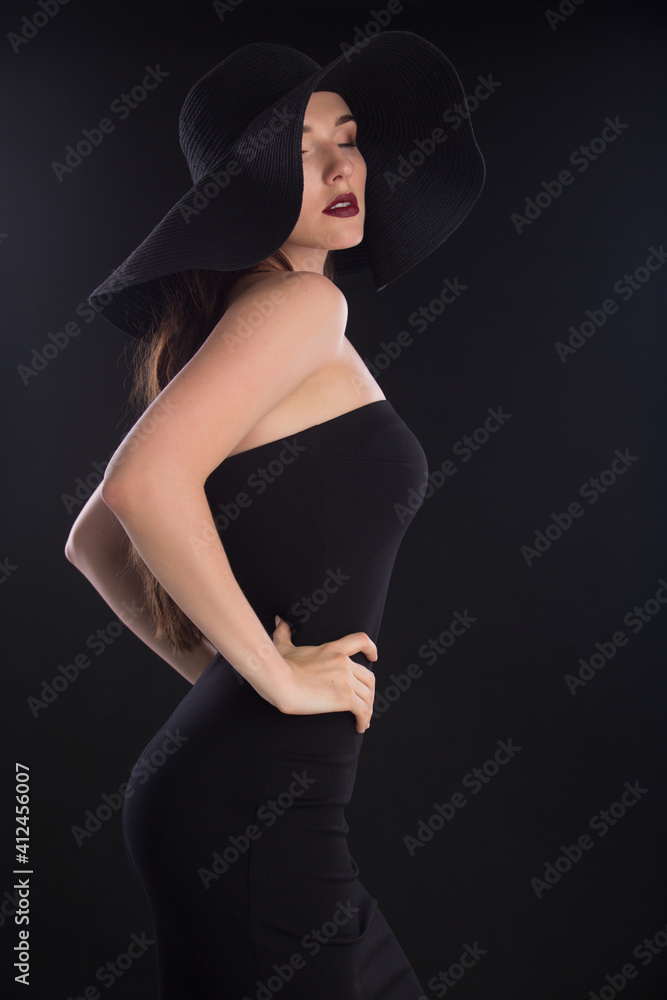 fashion portrait of a young and very beautiful girl in a black hat on a black background fashion portrait of a young and very beautiful girl in a black hat on a black background