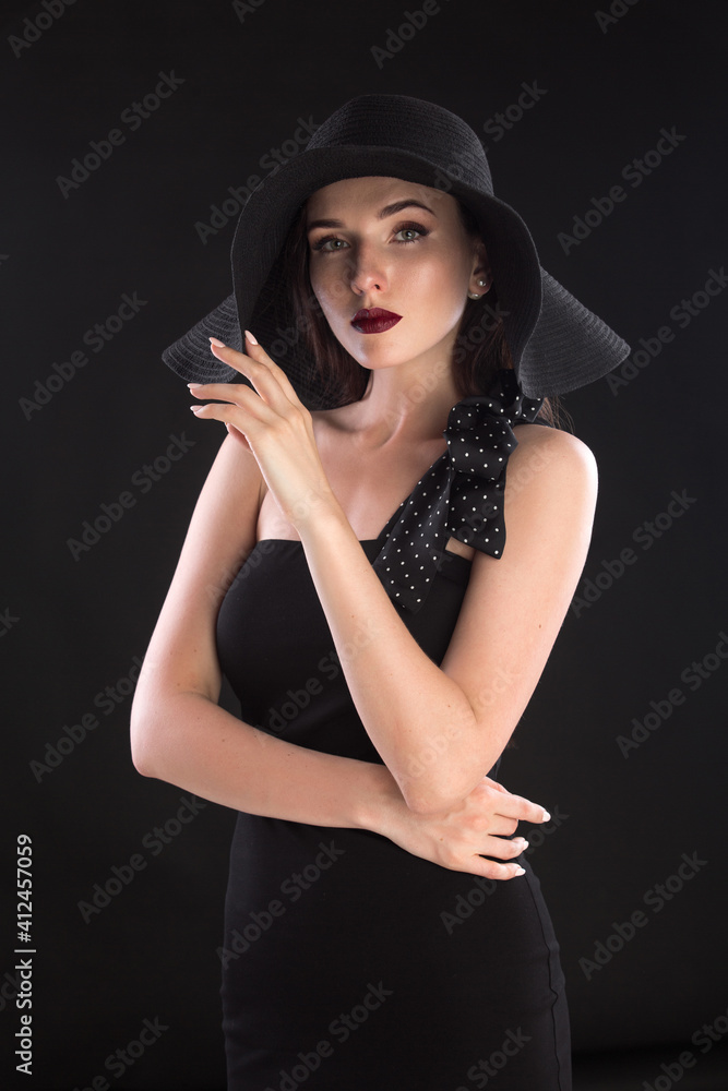 fashion portrait of a young and very beautiful girl in a black hat on a black background fashion portrait of a young and very beautiful girl in a black hat on a black background