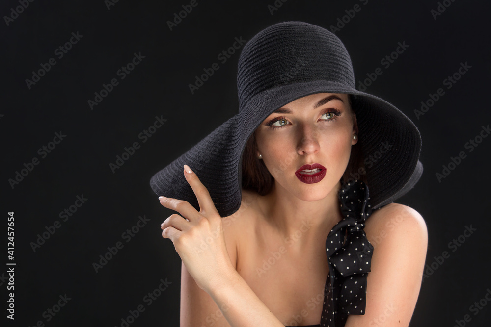 fashion portrait of a young and very beautiful girl in a black hat on a black background fashion portrait of a young and very beautiful girl in a black hat on a black background