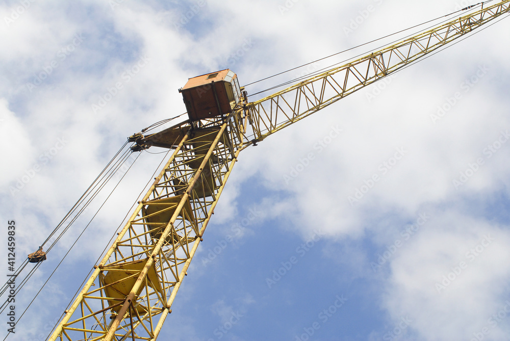 Yellow lifting crane. Lifting machine view against the blue sky. Yellow lifting crane. Lifting machine view against the blue sky.