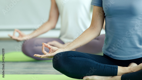 Young and beautiful women sitting and practicing yoga together with easy and relax gesture in lotus pose, the basic of yoga doing