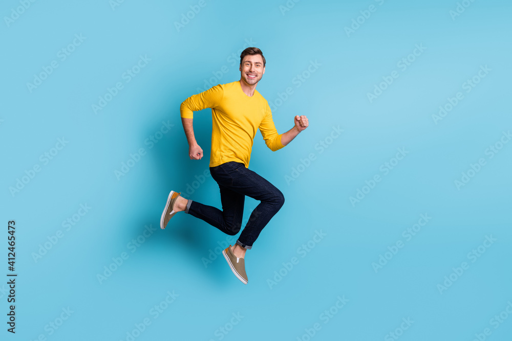 Full body profile photo of satisfied person running jumping toothy smile isolated on blue color background