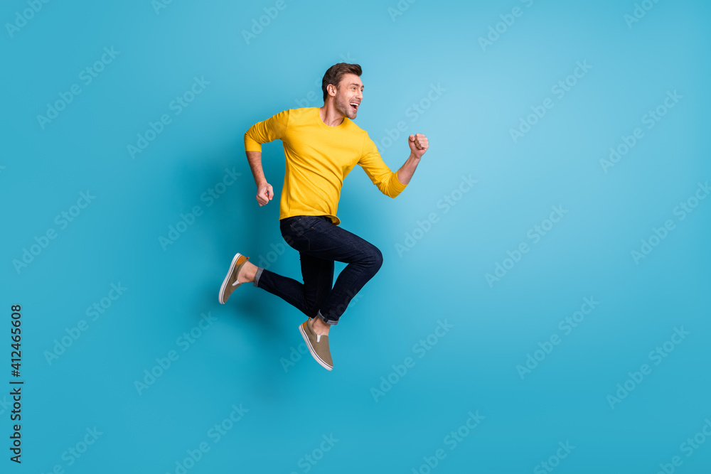 Full length body size view of attractive motivated cheerful guy jumping running isolated over bright blue color background