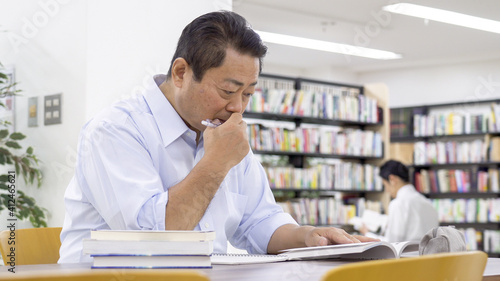 図書館で勉強する中高年男性