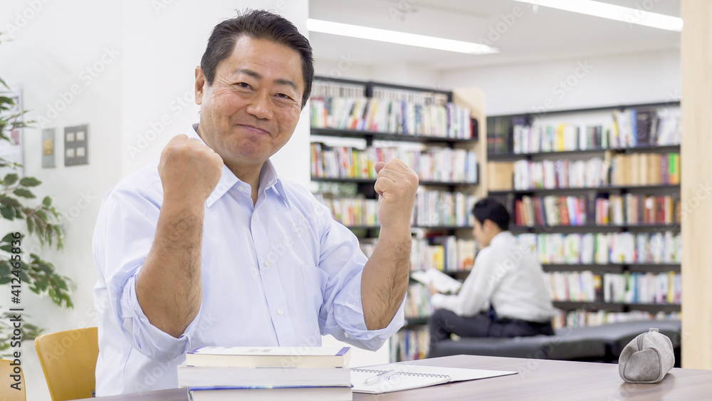 図書館で勉強する中高年男性 図書館で勉強する中高年男性