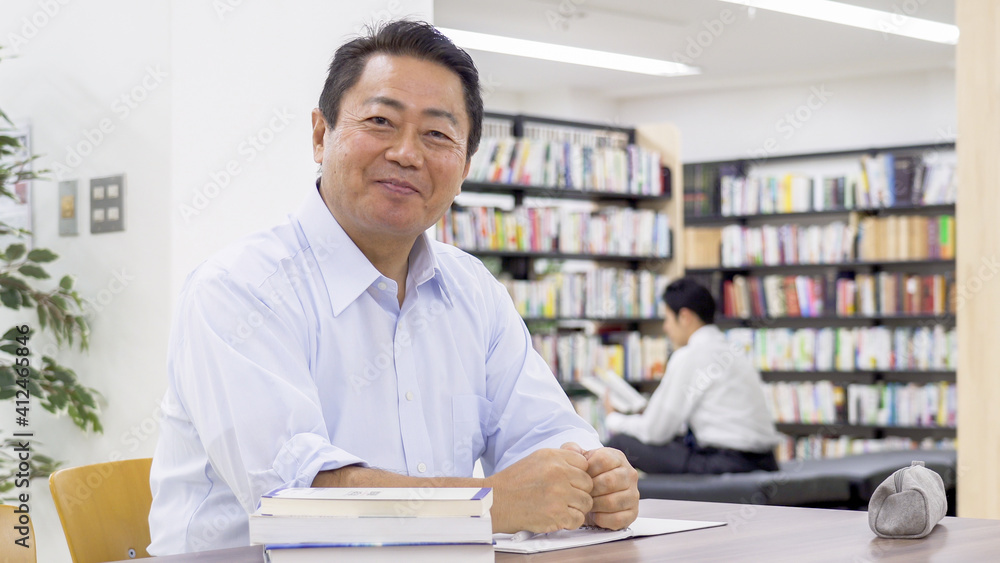 図書館で勉強する中高年男性 図書館で勉強する中高年男性