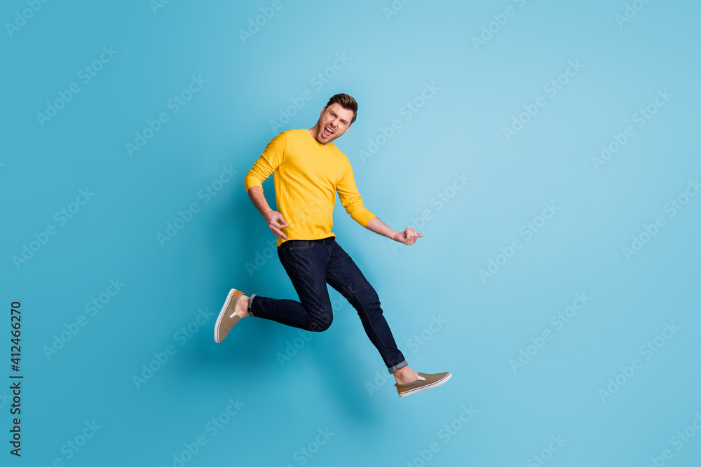 Full size photo of funky man jump up air play imagine guitar isolated on pastel blue color background