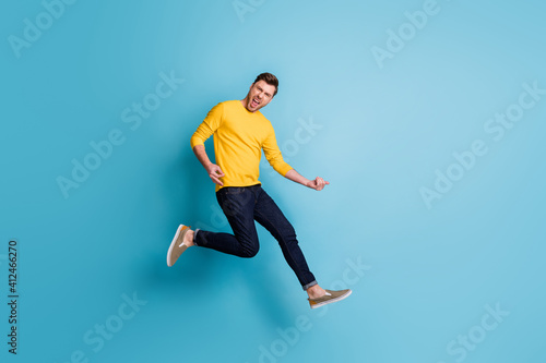 Full size photo of funky man jump up air play imagine guitar isolated on pastel blue color background