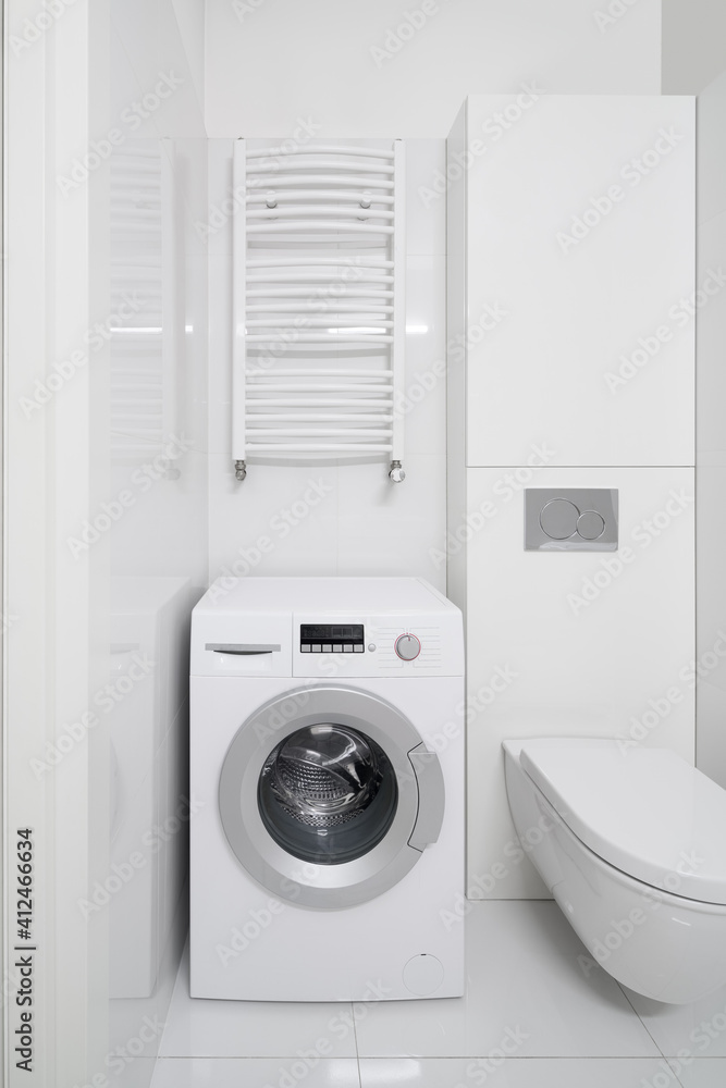 Washing machine in white bathroom Washing machine in white bathroom