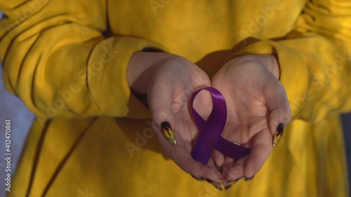 Hands holding purple ribbons, toning copy background, Alzheimer's disease, pancreatic cancer, epilepsy awareness, domestic violence awareness, fibromyalgia awareness, world cancer day photo