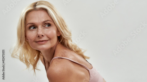 Cute middle aged woman looking at top to side