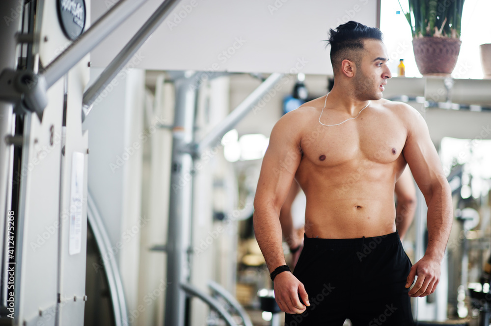 Muscular arab man training in modern gym. Fitness arabian men with naked torso doing exercises . Muscular arab man training in modern gym. Fitness arabian men with naked torso doing exercises .