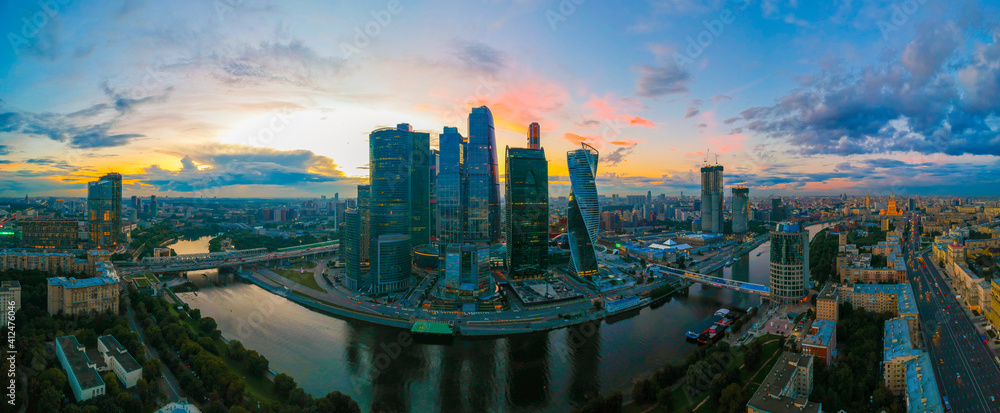 Obraz premium Large panorama view of summer Moscow with skyscrapers of Moscow-City - a business district on the embankment of Moskva River at sunset, Russia. Top view aerial cityscape from the drone.