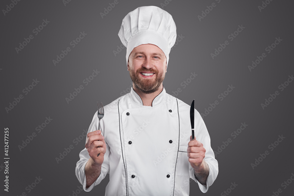 Optimistic chef with knife and fork Optimistic chef with knife and fork