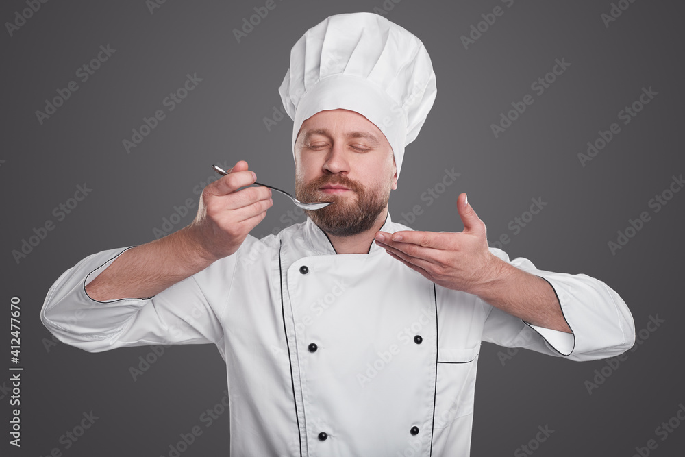 Bearded chef trying dish while cooking Bearded chef trying dish while cooking