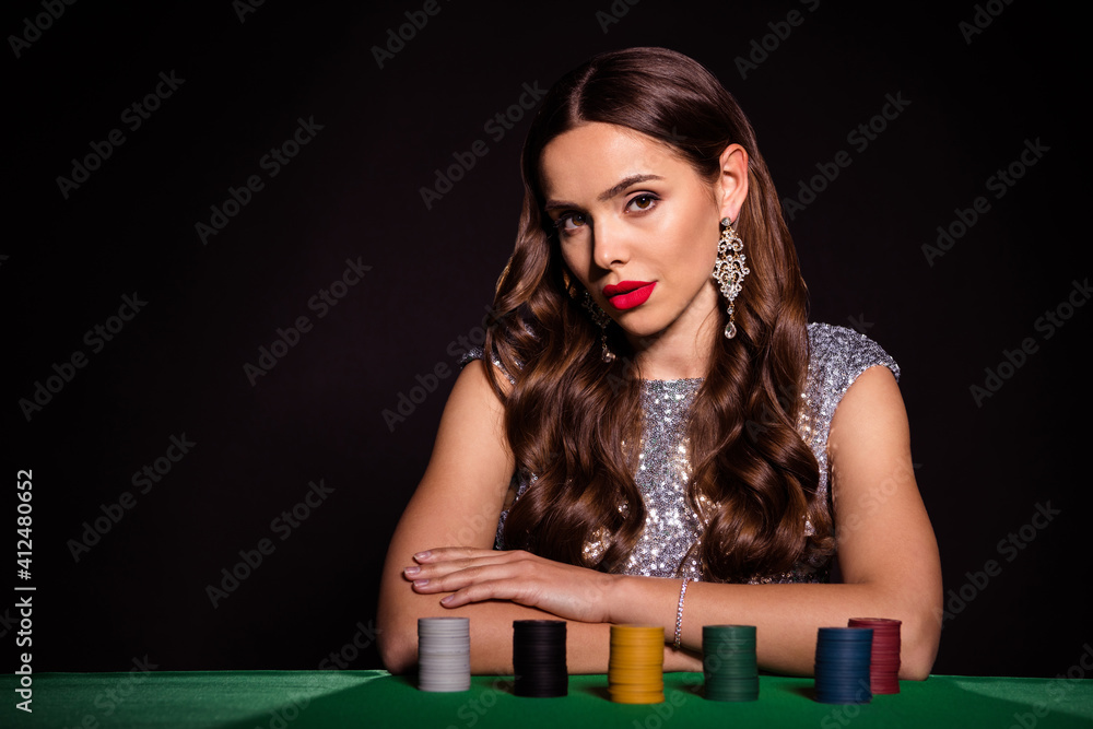 Photo of pretty fancy lady sit poker table tempting look camera wear earrings glossy dress isolated black color background Photo of pretty fancy lady sit poker table tempting look camera wear earrings glossy dress isolated black color background