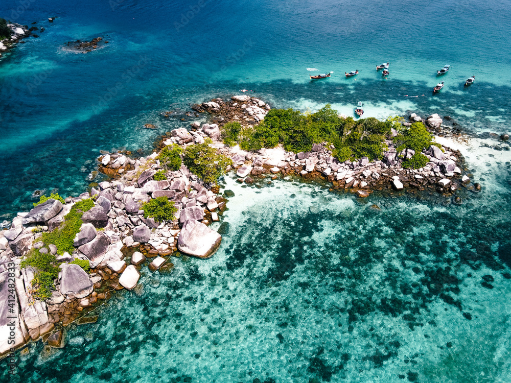 Obraz premium Aerial view of the long tail boats on tropical sea satun, Thailand ,Island and coral