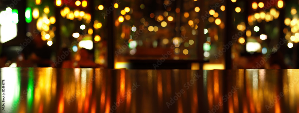 reflection of party light on wood table in pub or bar in Christmas night banner background