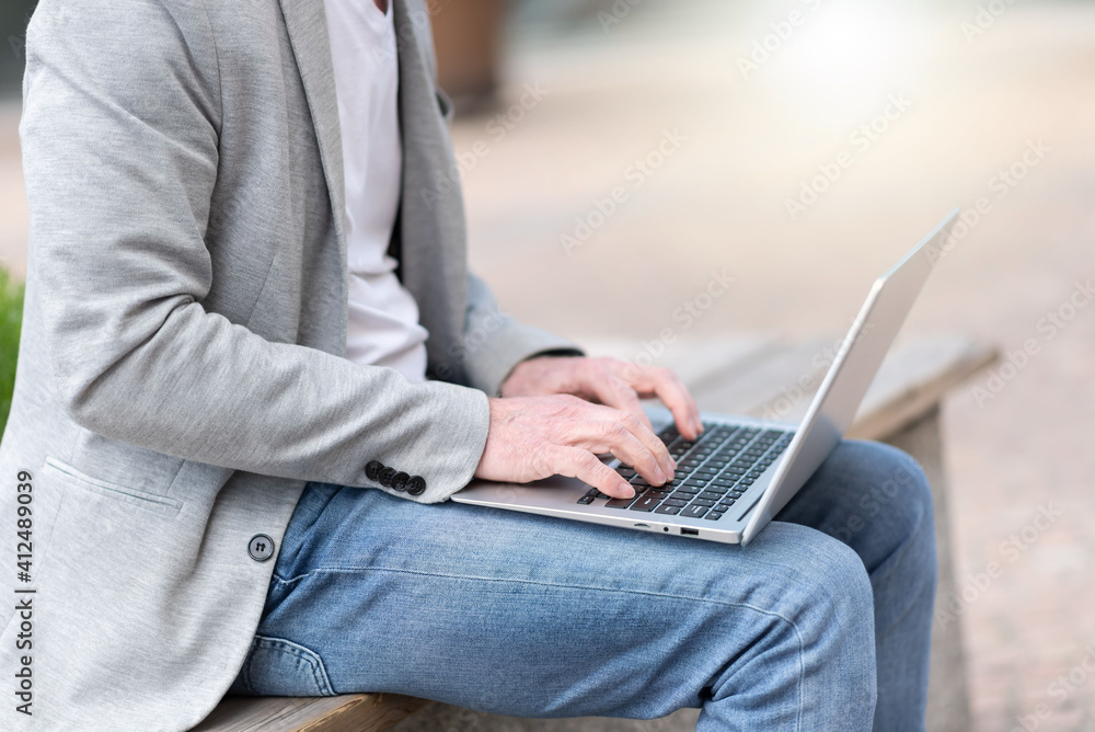 Naklejka premium Businessman using laptop outdoors