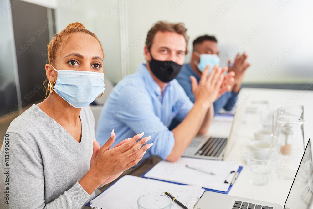 Business team with mask clapping while applauding