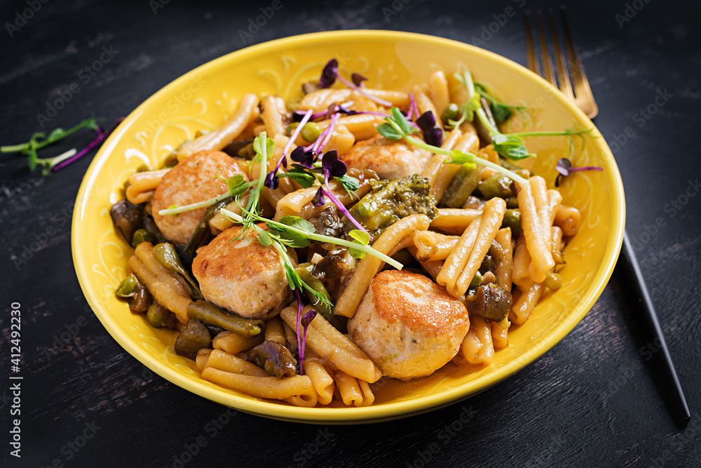 Caserecce pasta with meatballs in sweet and sour sauce and vegetables in bowl. Caserecce pasta with meatballs in sweet and sour sauce and vegetables in bowl.