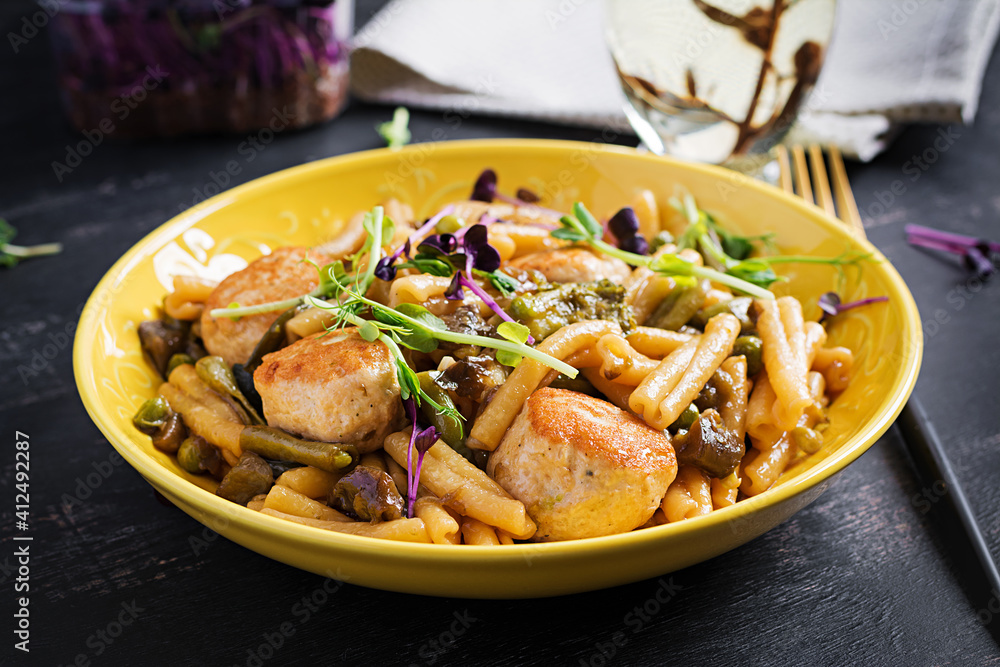 Caserecce pasta with meatballs in sweet and sour sauce and vegetables in bowl. Caserecce pasta with meatballs in sweet and sour sauce and vegetables in bowl.