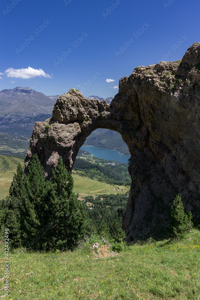 Natural stone arch of Piedrafita and views of the surrounding area in Pyrenees (Spain)