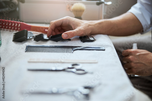 Male hairstylist cleaning his work place before the client in beauty parlor © Svitlana