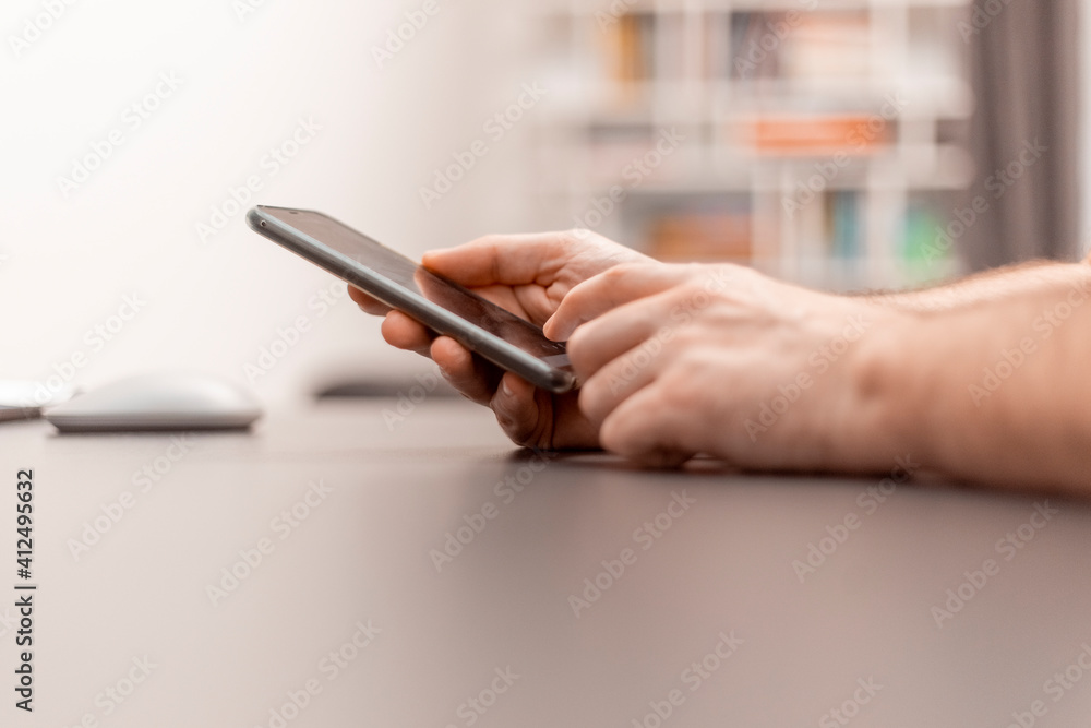 Close up view of hand with mobile phone. Work with the cell phone. Working from home, home office Close up view of hand with mobile phone. Work with the cell phone. Working from home, home office