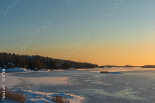 Sunset over the sea in winter. The sea is chained in ice