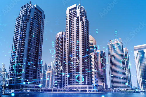 Skyscrapers of Dubai business downtown. International hub of trading and financial services. Technology theme icons hologram, Fintech concept. Double exposure. Dubai Canal waterfront. © VideoFlow