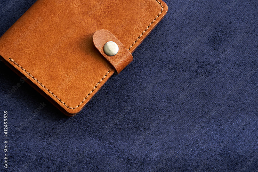 Red leather wallet on a blue velvet background. Copy space.