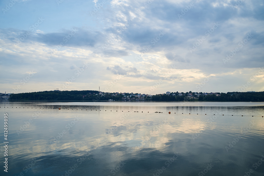 Amazing lake landscape in the evening. Blue yellow cloudy sky with reflection in water at sunset. Nature protection concept. Rural scene in countryside. Ecological conservation.Eco tourism development Amazing lake landscape in the evening. Blue yellow cloudy sky with reflection in water at sunset. Nature protection concept. Rural scene in countryside. Ecological conservation.Eco tourism development